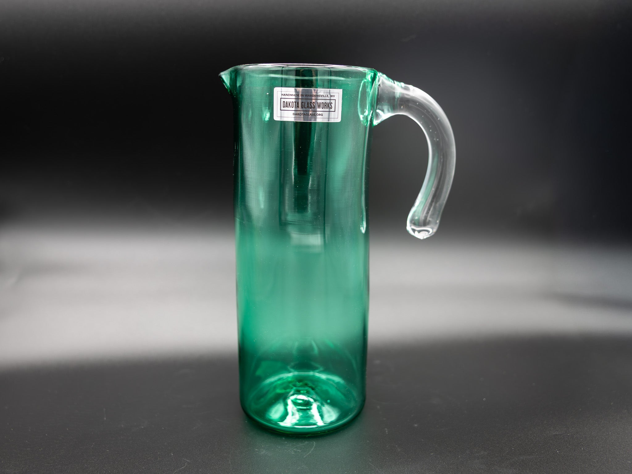 Green glass pitcher on a dark background