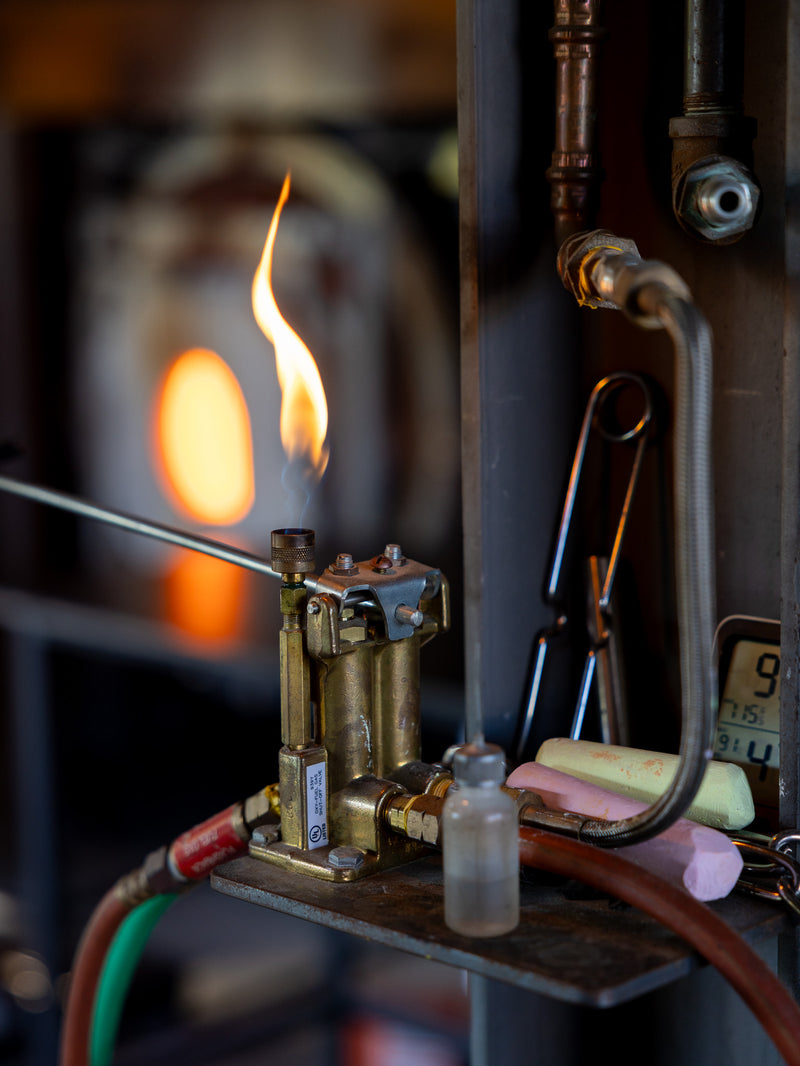 Close-up of a flame and metallic apparatus with blurred background