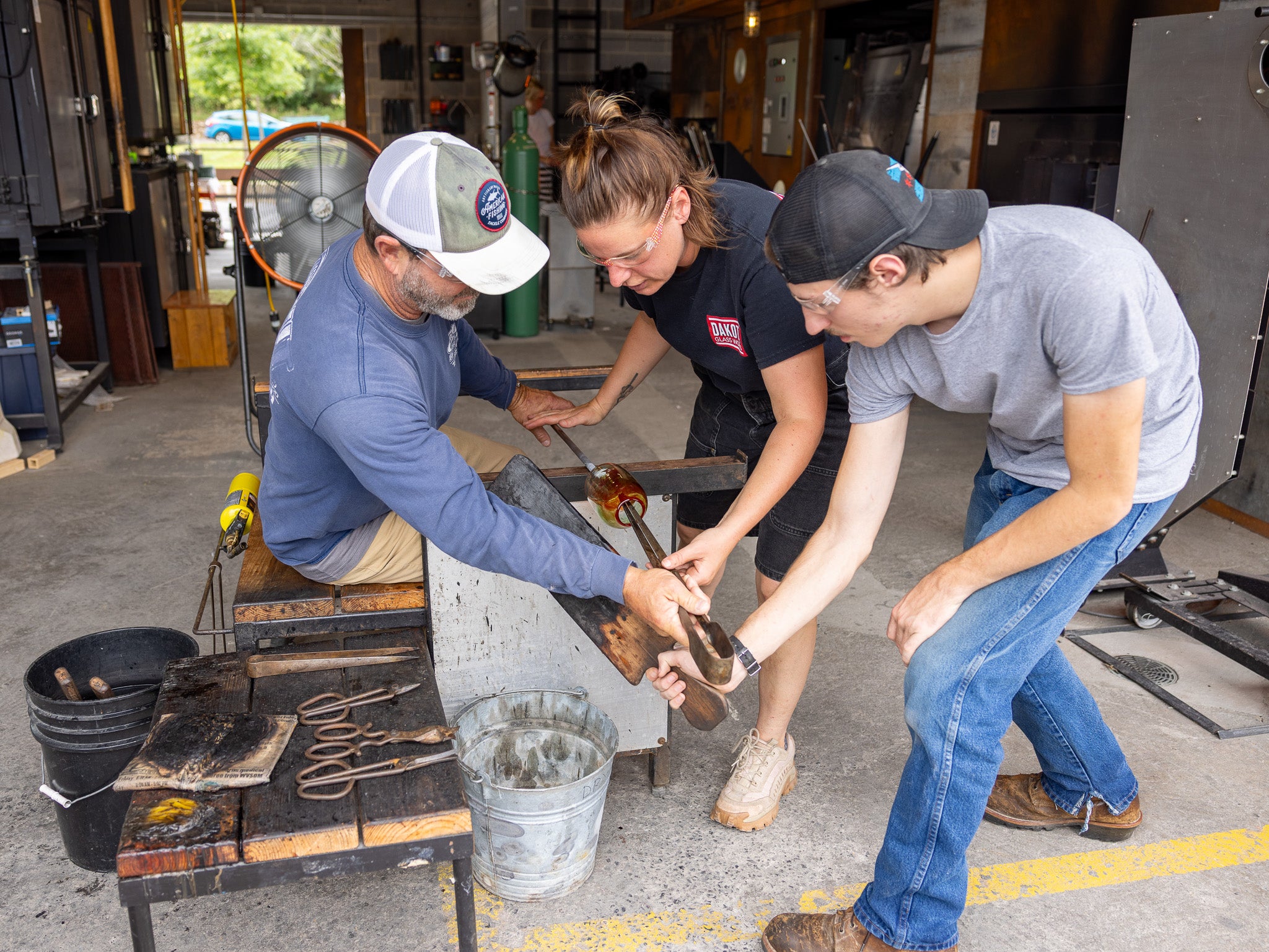 Three people working together in a workshop setting.