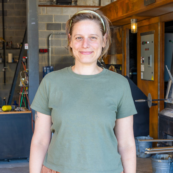 Person wearing a green shirt in a workshop setting