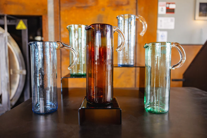 Set of glass pitchers on a wooden surface with a blurred background
